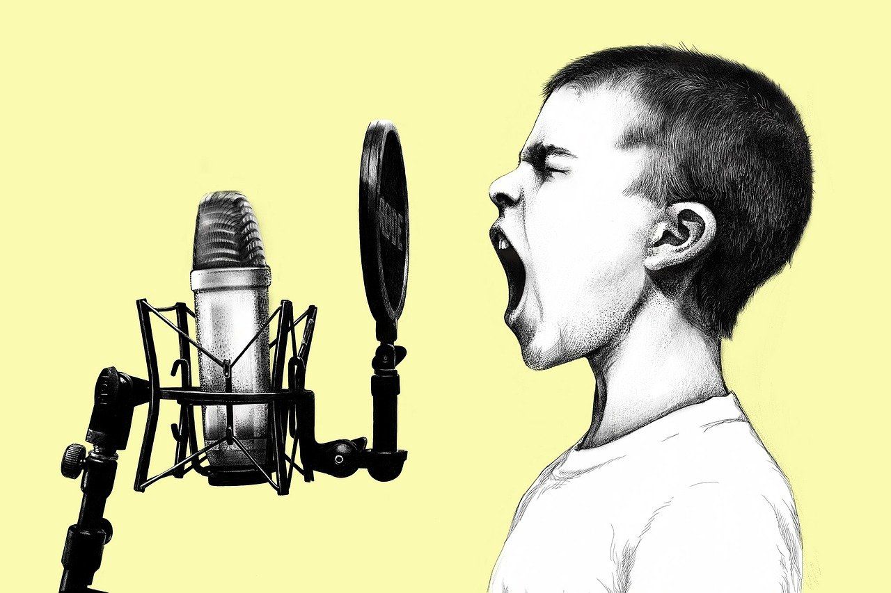 Un garçon crie ou chante dans un micro Rode pour une chronique radio